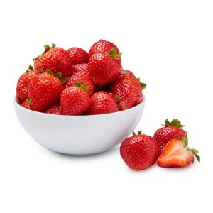 Organic strawberries in a white bowl with a few fresh berries beside it